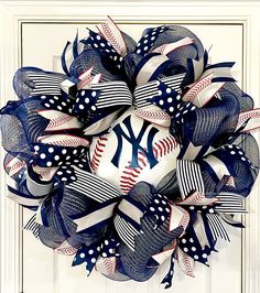 a new york yankees mesh wreath on a white door with red, white and blue decorations