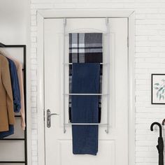 a white door with a towel rack on it and an umbrella hanging from the side