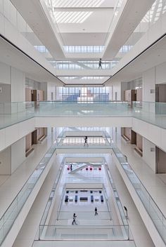 the inside of an empty building with people walking around and looking up at the ceiling