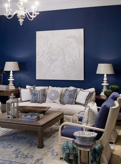 a living room with blue walls and white furniture