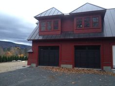 a red house with two black garage doors