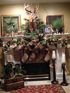 a fireplace decorated for christmas with deer heads and stockings on the mantel, surrounded by greenery