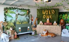 an animal themed birthday party with jungle animals and decorations on the walls, including fake giraffes