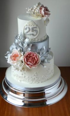 a three tiered cake with white frosting and pink flowers