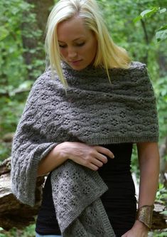 a woman wearing a gray knitted shawl in the woods