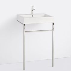 a white bathroom sink sitting on top of a metal stand with a faucet