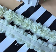 white flowers on black and white striped table cloth with scissors next to it in the background