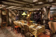 an old fashioned dining room with many chairs and table cloths on the long table