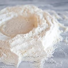 a bowl filled with flour sitting on top of a counter