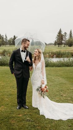 a bride and groom kissing under an umbrella