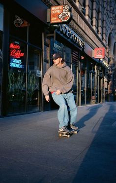 a man riding a skateboard down the side of a street next to a tall building