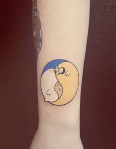 a person with a small tattoo on their arm that has an image of a cartoon character