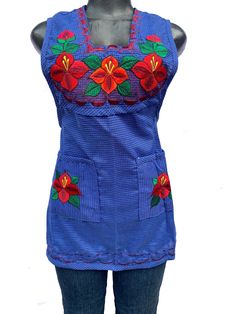 a woman's blue top with red flowers on the front and green leaves on the back