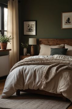 a large bed sitting next to a window in a room with wooden floors and green walls