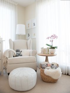 a living room filled with furniture and a baby's crib next to a window