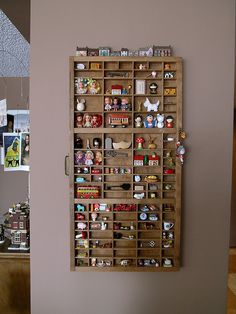 a wooden shelf filled with lots of different types of items on top of a wall