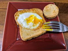 a piece of bread with an egg in the middle on it and a fork next to it