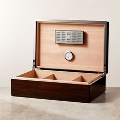 an open wooden box with a clock in the middle and two drawers on each side