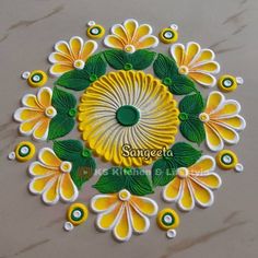 an intricate design with yellow flowers and green leaves in the center on a marble surface