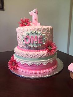 a pink and white cake with flowers on it