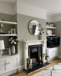 a living room filled with furniture and a fire place in front of a flat screen tv