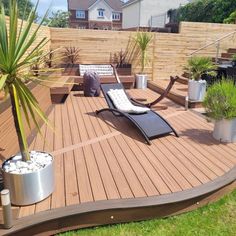 a wooden deck with chaise lounges and potted plants