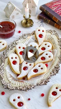 some cookies are arranged on a plate with red and white decorations next to them,