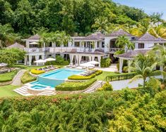 an aerial view of the house with pool and surrounding landscaping, surrounded by lush greenery