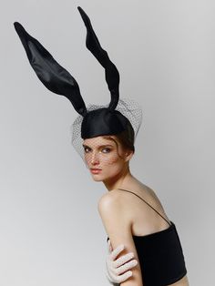 Designer "Bunny" Hat with Veil - a unique and stylish accessory that will perfectly complement your look for parties, photoshoots, and special events.  Made from black satin, this hat exudes elegance, while the veil adds a touch of mystery and charm. The metal hoops ensure a comfortable fit, and the decorative ears make your appearance playful and unforgettable. This accessory is created for those who want to stand out and leave a lasting impression at any event. It's perfect for themed parties, photoshoots, or elegant chic evenings. Material: Black satin Details: Veil, metal hoops, wire Dimensions:  * Depth of the hat along the parting: 19 cm (7.48 inches) * Across: 23 cm (9.06 inches) * Headband (fastening): 34 cm (13.39 inches) * Ear: 39 cm (15.35 inches) Highlight your individuality wi Satin Veil, Hat Photoshoot, Headpiece Fashion, Veil Hat, Hat With Veil, Veiled Hats, Veil Accessories, Bunny Hat, Unique Hats