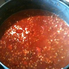 a pot filled with lots of red sauce on top of a stove