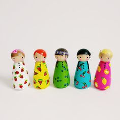 five wooden dolls are lined up in a row