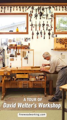 a man working on a workbench in a workshop with tools hanging from the wall