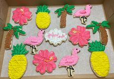 decorated cookies in the shape of pineapples, flamingos and other tropical animals