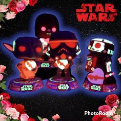 three star wars figurines sitting on top of each other in front of flowers