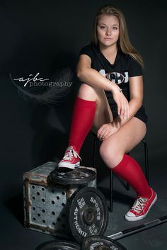 a young woman sitting on top of a chair next to a barbell weight machine