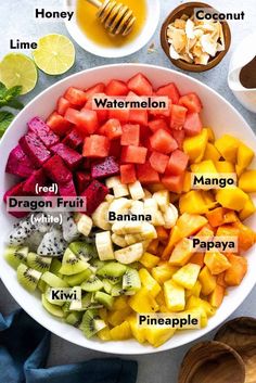 a bowl filled with different types of fruits next to bowls of honey, watermelon, dragon fruit, mango and pineapple