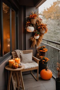 a porch decorated for fall with pumpkins, candles and wreaths on the balcony