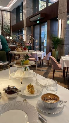 a table topped with plates filled with food next to a tall glass vase full of flowers