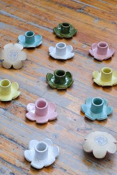 several small cups and saucers on a wooden table with one sitting in the middle