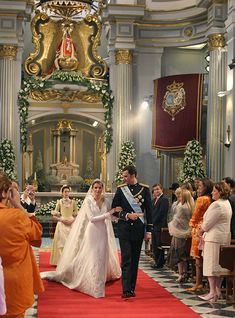 a bride and groom walking down the aisle at their wedding ceremony in an ornate church