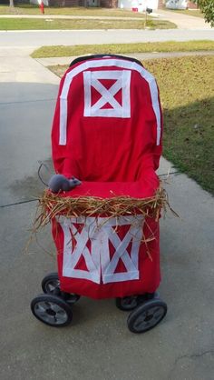 a little red wagon with hay in it on the sidewalk