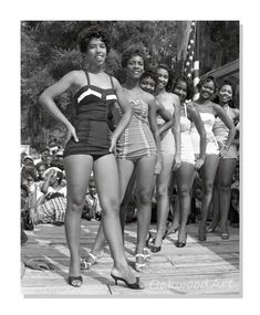 an old black and white photo of women in bathing suits standing on a dock with people watching