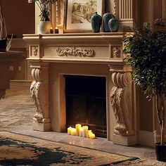 candles are lit in front of an ornate fireplace