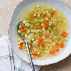 a white bowl filled with soup next to a spoon