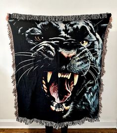 a black and white tiger tapestry hanging on the wall with it's mouth open