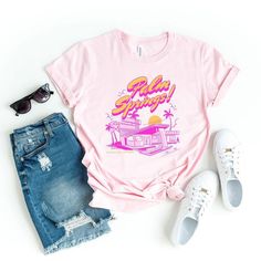 Looking for a cute versatile top to wear? Make sure to grab one of our Graphic tees! This soft and comfortable graphic tee is the perfect top for any outfit. It can be paired with biker shorts, jeans, or even a simple skirt/dress! This tee is true-to-size, so be sure to order your regular t-shirt size! If you are looking for a more oversized look, make sure to size up! Pink Graphic Print T-shirt For Loungewear, Funny Print Tops For Spring Streetwear, Retro Tops With Funny Print For Spring, Spring Funny Print Graphic Tee, Trendy Spring Top With Front Print, Retro Funny Print Tops For Spring, Trendy Funny Print Tops For Loungewear, Trendy Tops With Funny Print For Loungewear, Spring Trendy Pre-shrunk T-shirt