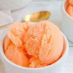 two white bowls filled with orange ice cream