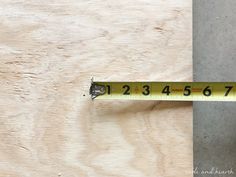 a measuring tape is on top of a piece of wood