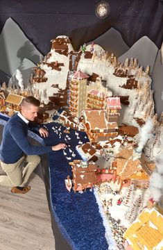 a man standing in front of a giant gingerbread castle