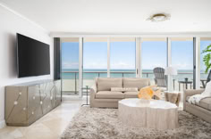 a living room filled with furniture and a flat screen tv mounted to the side of a wall